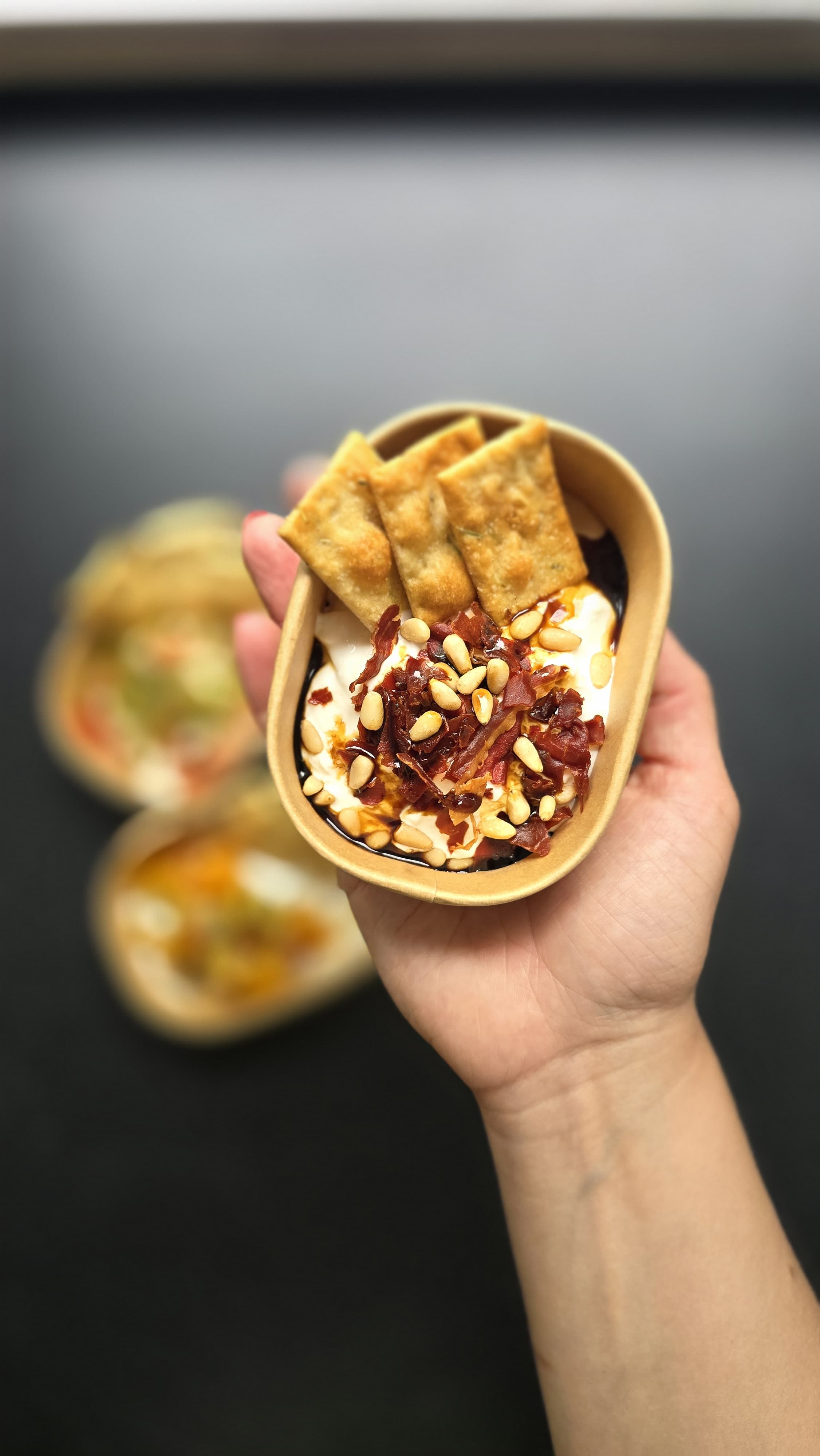 Een vers opgemaakte burrata-bowl met crispy prosciutto, pijnboompitten en scrocchi-toastjes